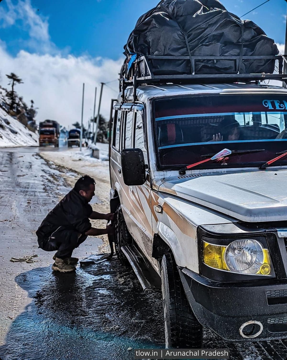 Travellers standing beside their Explore Roots cab on a hill road